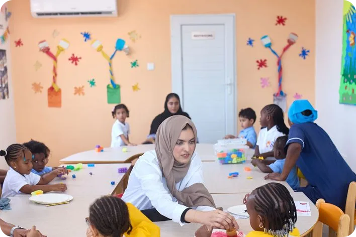 An educator building words with a child using letter cards