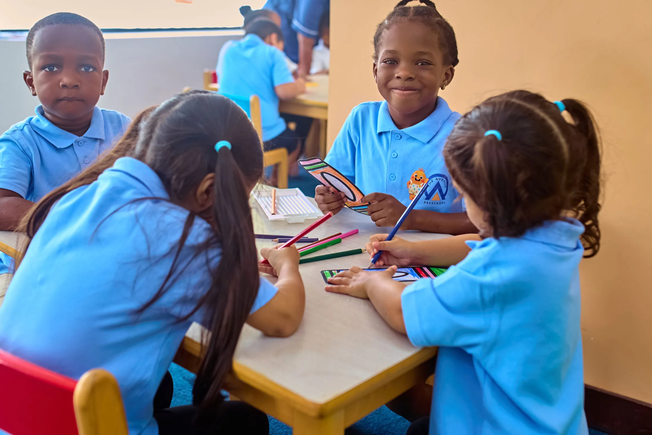 Children colouring and creating together at a classroom table